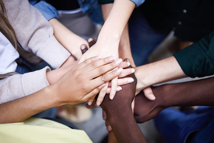 Top view young people putting hands together